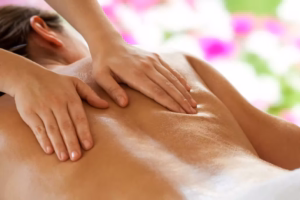 Zwei Hände massarieren Rücken