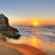 Sonnenaufgang am Meer mit Felsen im Vordergrund
