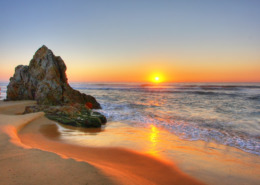 Sonnenaufgang am Meer mit Felsen im Vordergrund